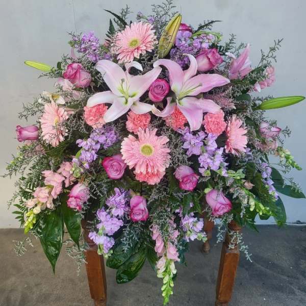 Large pink and purple floral spray with lilies and roses