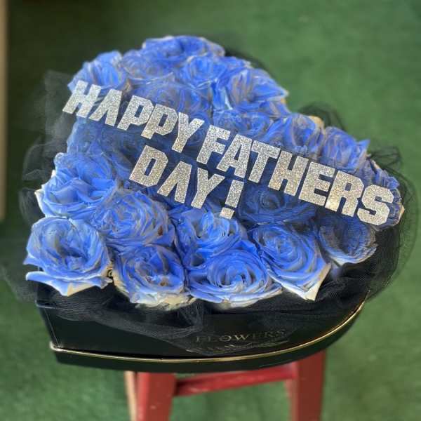 Blue rose arrangement with a glittery Happy Fathers Day sign in a black box