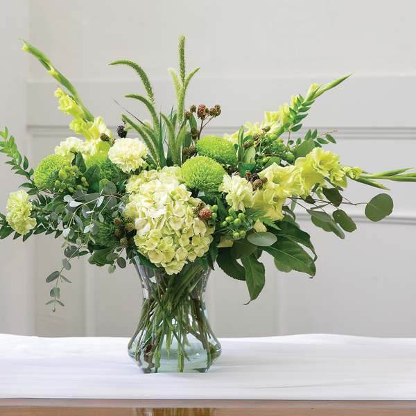 Green floral arrangement in a clear glass vase