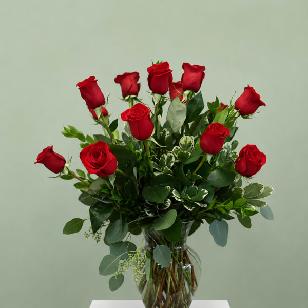 Red roses arranged in a clear glass vase
