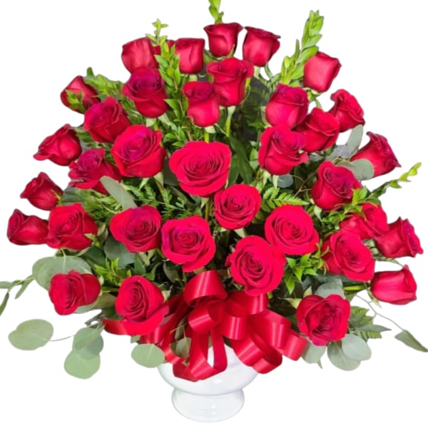 Bouquet of red roses in a white vase with a red ribbon