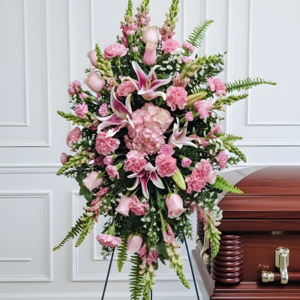 Pink funeral spray beside a casket