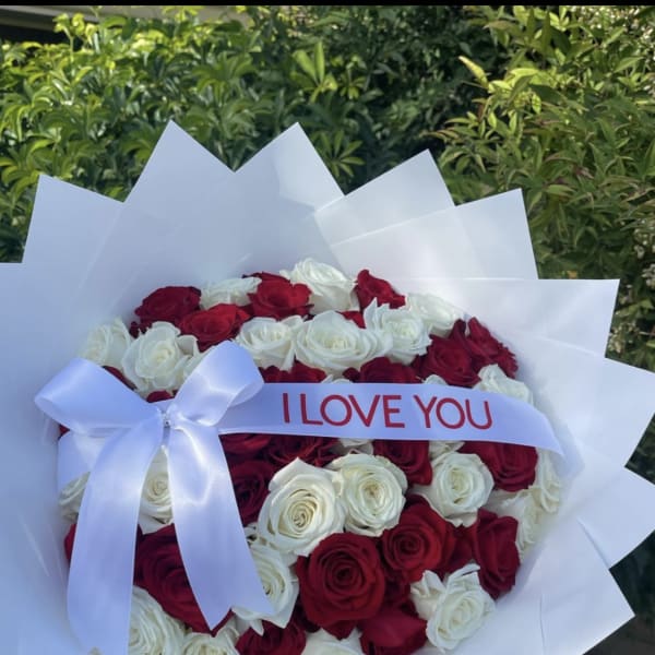 Bouquet of red and white roses with a white ribbon reading I LOVE YOU