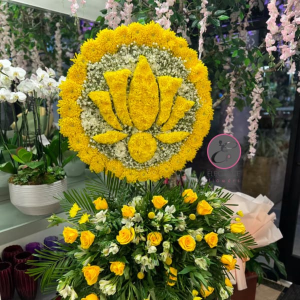 Large yellow floral standing tribute with a lotus design and roses below