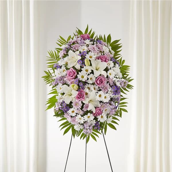 Standing floral wreath with white lilies, pink roses, and purple daisies