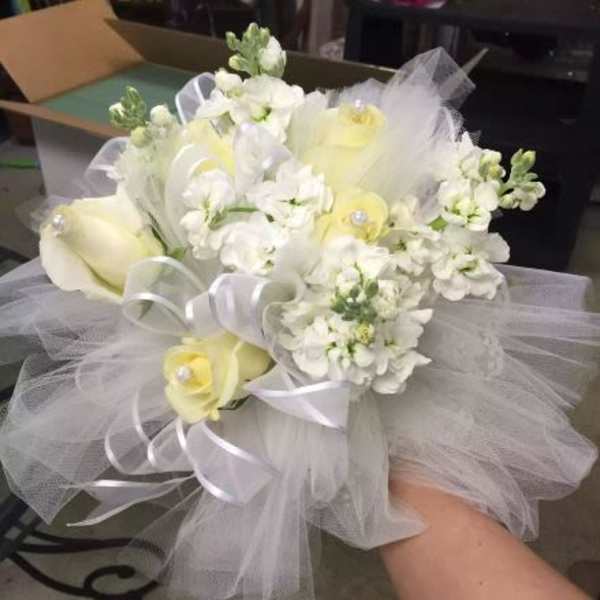 Bridal-style hand-tied bouquet of white and pale yellow flowers with tulle and ribbon