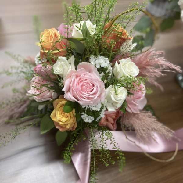 Bouquet of pink, white, and peach roses with ribbon wrap