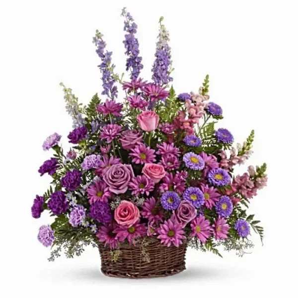 Purple and pink mixed flower arrangement in a wicker basket