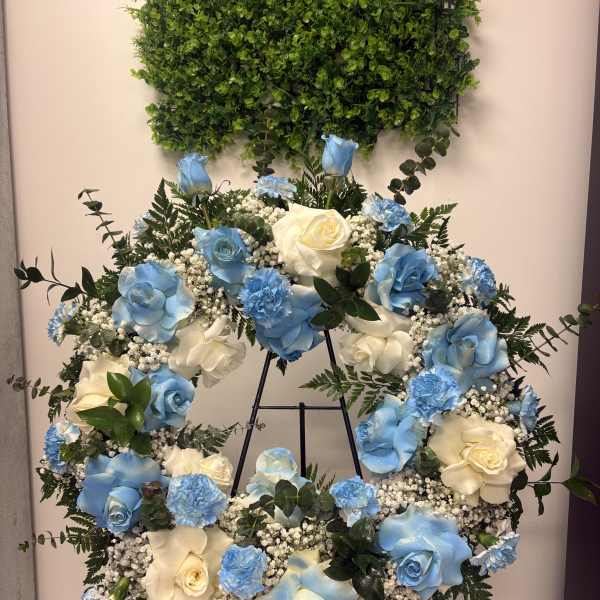 Blue and white rose wreath on a black easel