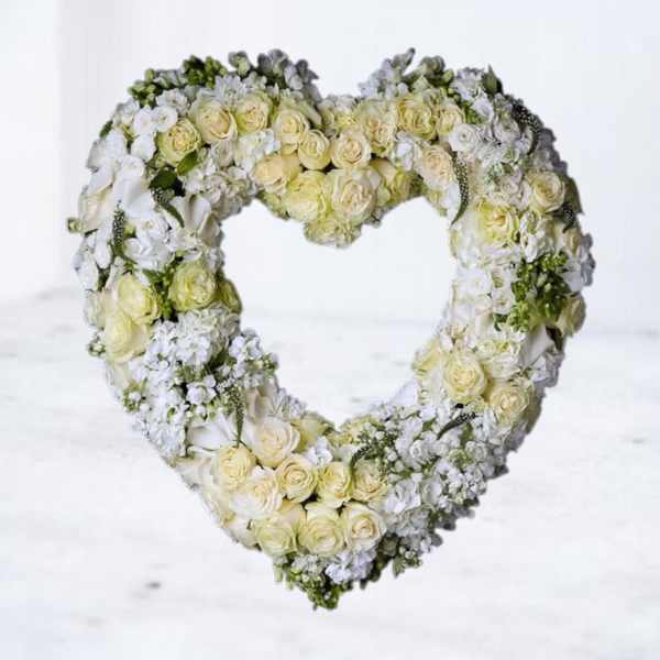Heart-shaped floral wreath of white and pale yellow roses