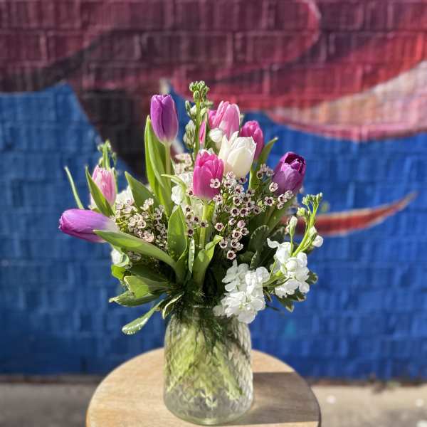 Bouquet of pink and purple tulips in a glass vase