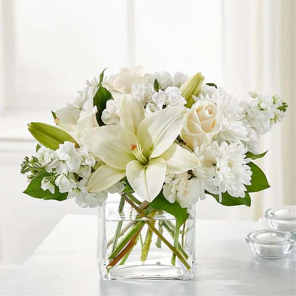 White lilies and roses in a clear glass vase