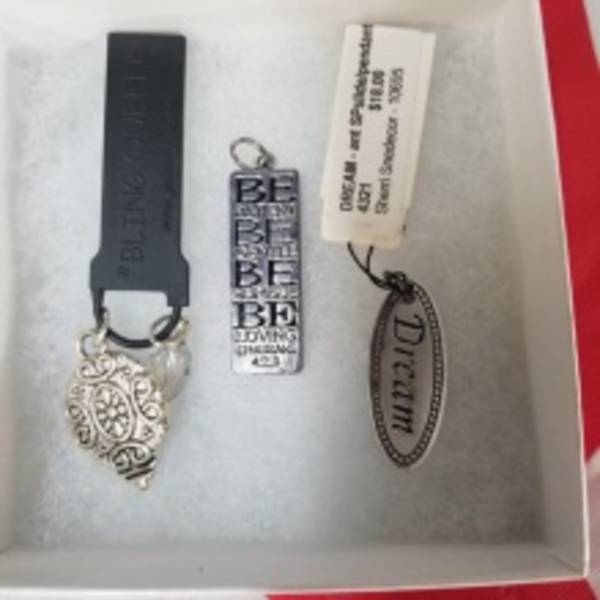 Three decorative keychain charms in a gift box