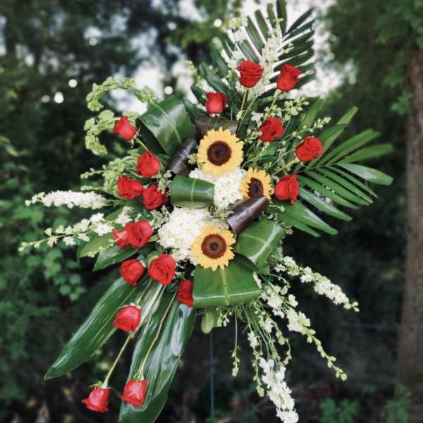 Standing floral spray with red roses, sunflowers, and white blooms