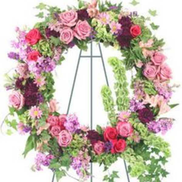 Floral wreath on a metal easel with pink and purple flowers