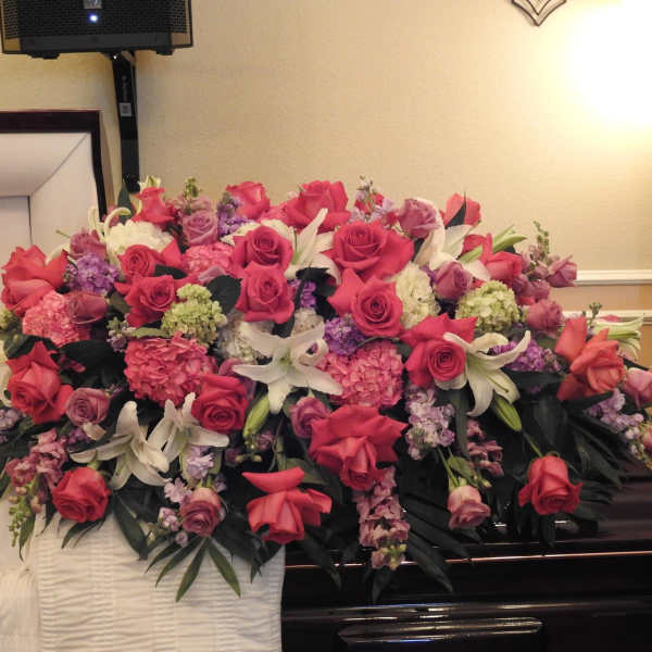 Large pink and white floral casket spray with roses and lilies