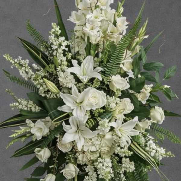 White floral standing spray on a black easel