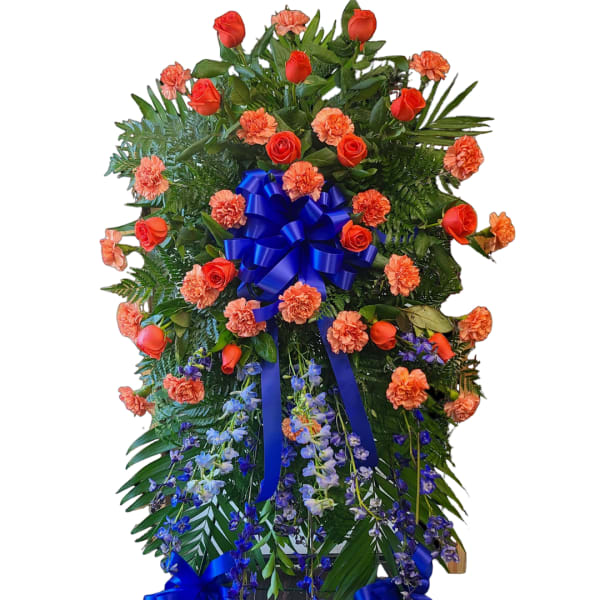 Standing floral spray with red roses, orange carnations, and blue ribbon