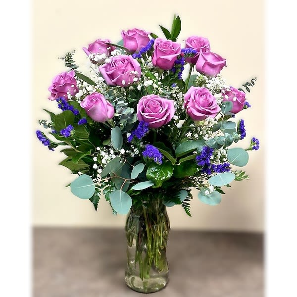 Bouquet of pink roses and purple filler flowers in a glass vase
