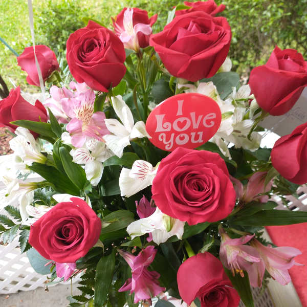 Bouquet of red roses and pink-white alstroemeria with a love-you pick