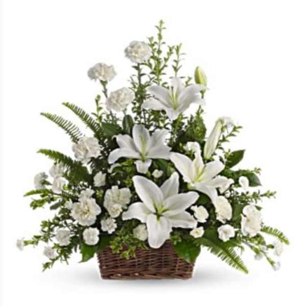 White lilies and carnations arranged in a wicker basket