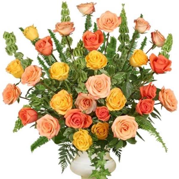 Mixed roses in peach, yellow, and coral in a white vase