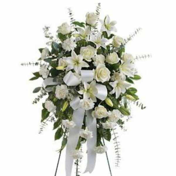 White floral standing spray with ribbon on an easel
