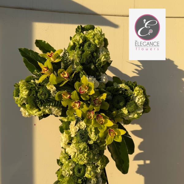 Cross-shaped floral tribute with green orchids and hydrangeas on a stand