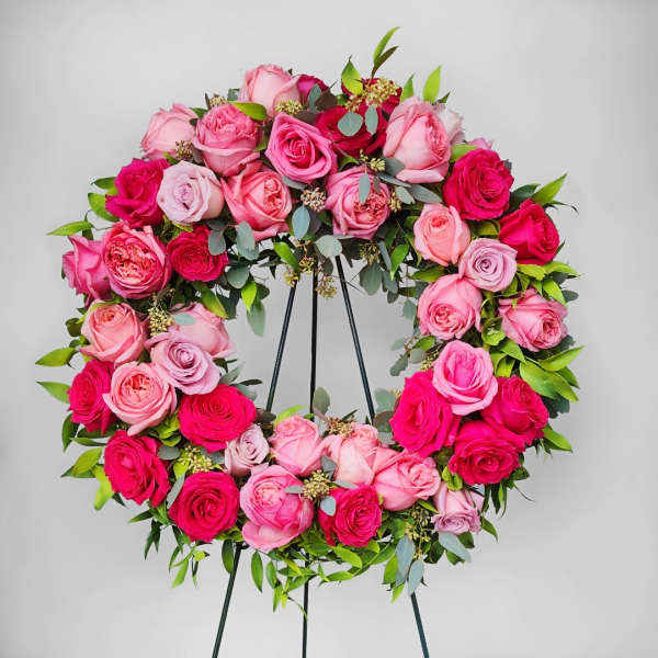 Pink and red rose wreath on a black stand