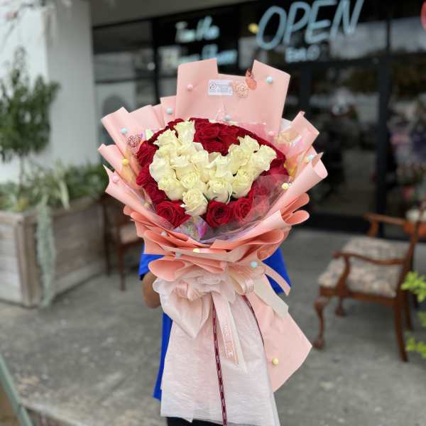 Large bouquet of red and white roses wrapped in pink paper