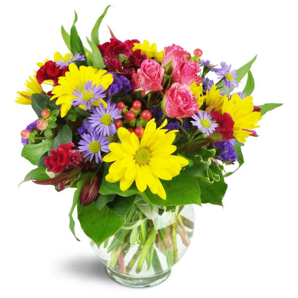 Colorful mixed bouquet of daisies, roses, and carnations in a glass vase