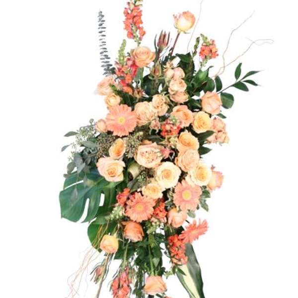 Tall peach and coral floral spray on an easel