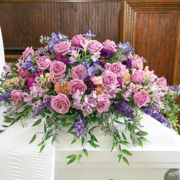 Large pink and purple floral casket spray with roses and lilies