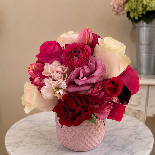 Pink and red rose bouquet in a textured pink vase