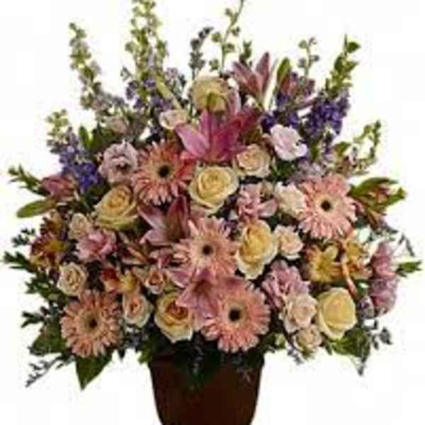 Mixed pink and cream flowers arranged in a brown urn vase
