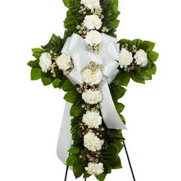 White floral cross wreath with a satin ribbon