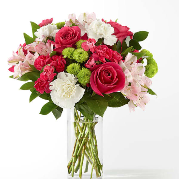 Pink roses, carnations, and alstroemeria in a clear glass vase
