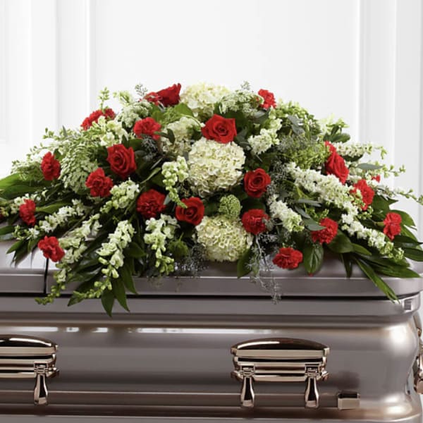 Red roses and white flowers arranged on a casket