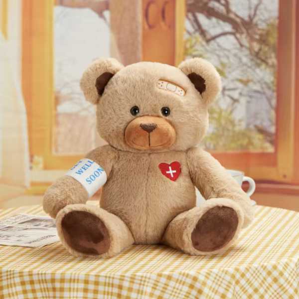 Plush teddy bear with a bandage and "get well soon" arm wrap