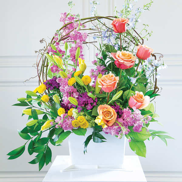 Colorful floral arrangement in a white container with roses and lilies