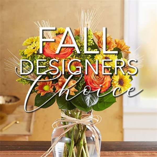 Mixed orange and yellow flowers in a glass vase with a ribbon