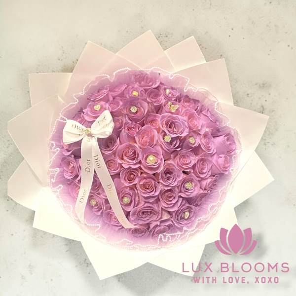 Pink rose bouquet wrapped in pale paper with a Dior ribbon