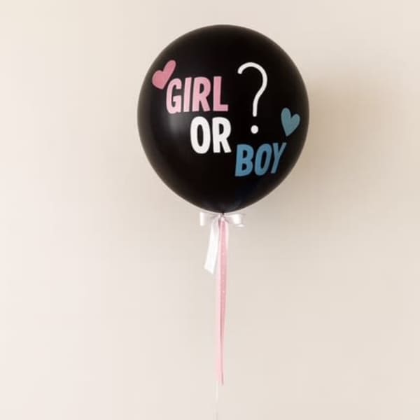 Black gender reveal balloon with pink and blue text, tied to a cluster of blue and pink balloons