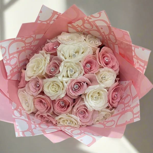 Bouquet of pink and white roses wrapped in pink paper