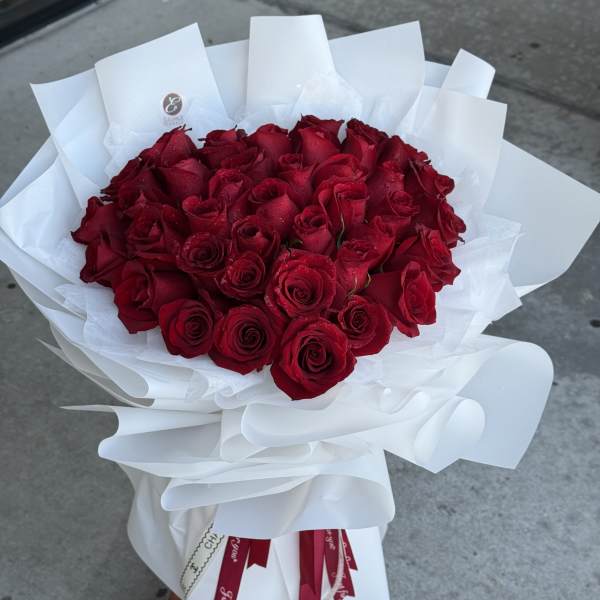 Bouquet of red roses wrapped in white paper