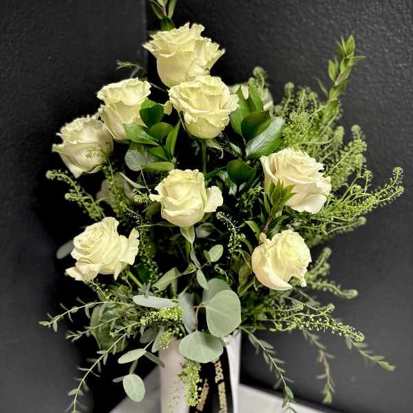 Cream roses in a white vase with airy greenery