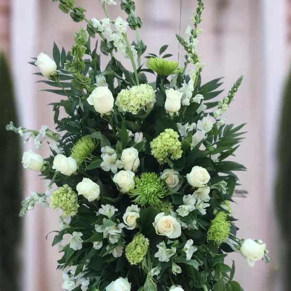 Tall white and green floral standing spray on an easel