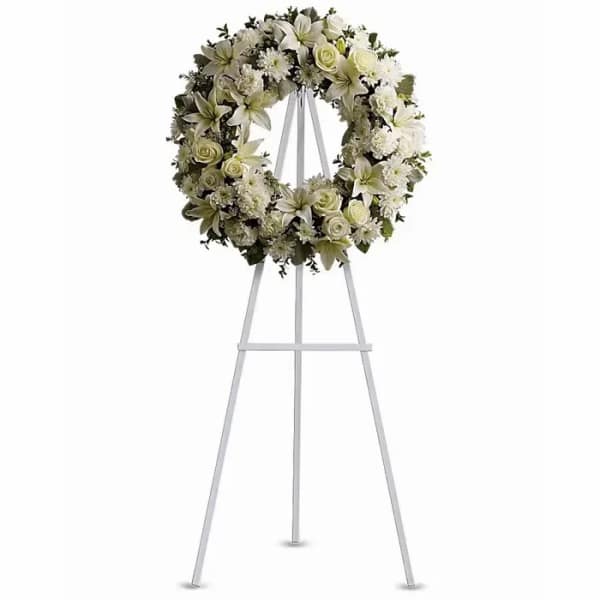 White floral wreath on a metal easel stand