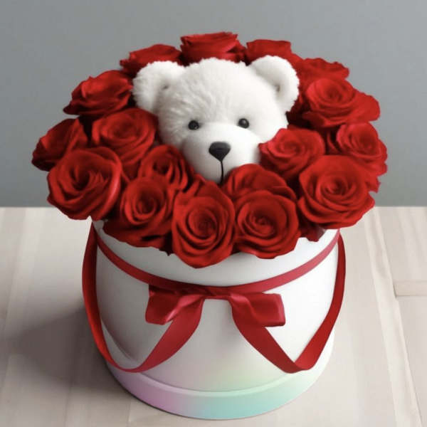 Red roses arranged around a white teddy bear in a round white box