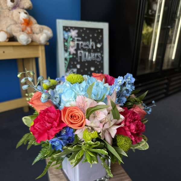 Colorful mixed bouquet in a square glass vase